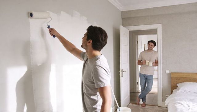 Two Men Painting Bedroom Together Bringing Coffee During Home Renovation Morning