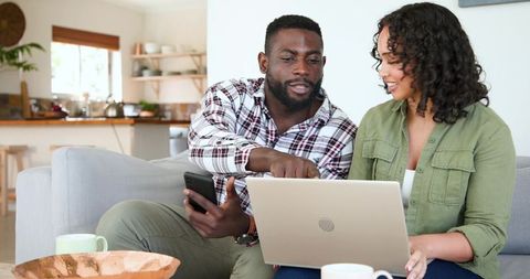 Diverse Couple Collaborating on Laptop in Bright Living Room