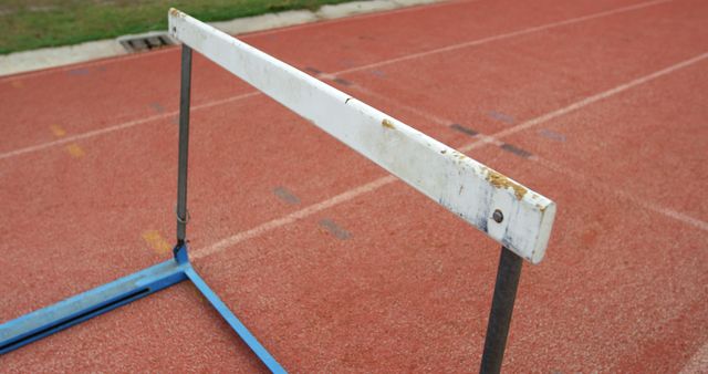 Close-up image of a single hurdle set on an outdoor running track. Ideal for content related to sports, athletics, track and field events, fitness training, or competitive racing.