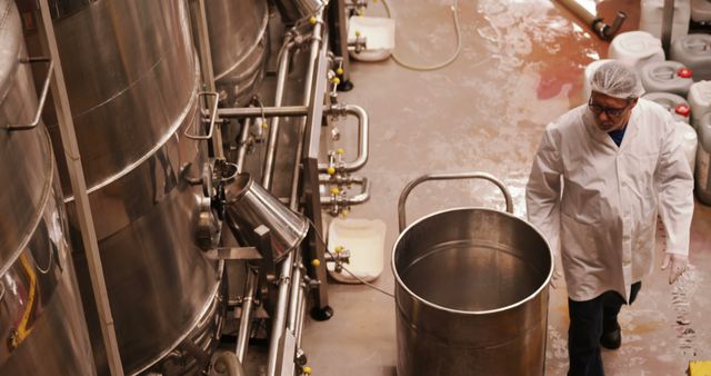 Industrial Worker Inspecting Equipment in Beverage Manufacturing Facility - Download Free Stock Images Pikwizard.com