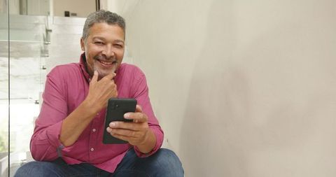 Smiling Man Using Smartphone in Stylish Home Interior
