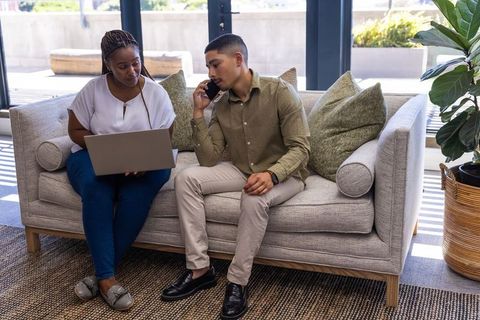 Diverse Coworkers Collaborating on Couch in Modern Office Setting