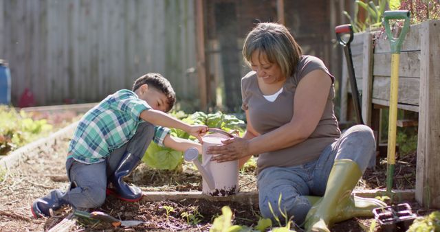 Grandmother and young grandson enjoying time together in the garden, planting and watering plants. They are sitting on the soil, engaged in gardening activities like filling a pot with soil. The image shows intergenerational bonding and can be used in contexts related to family time, gardening activities, teamwork, and spending time outdoors.