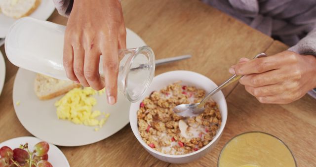 Image of hands of caucasian man preparing cereals for breakfast. Lifestyle and spending time at home concept.