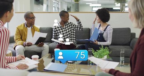 Diverse team collaborating in lounge with man in mustard jacket and follower count 75