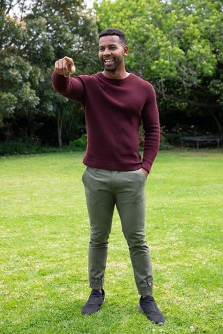 Joyful man in casual attire pointing in park setting