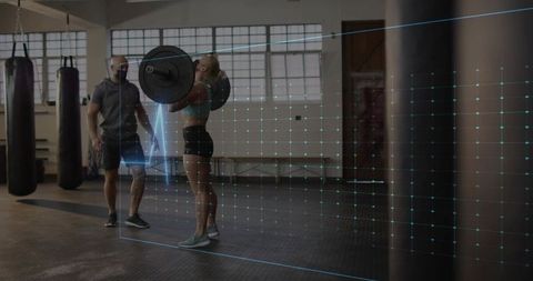 Female Athlete Lifting Barbell while Masked Trainer Spotting with Augmented Reality Grid