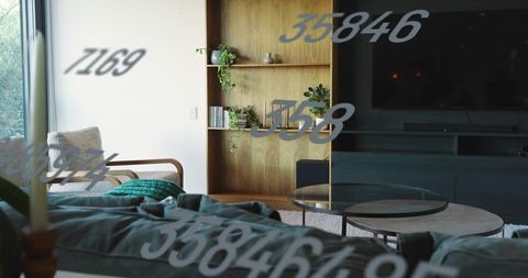 Low-profile gray sofa with green throw and nested glass tables in cozy living room
