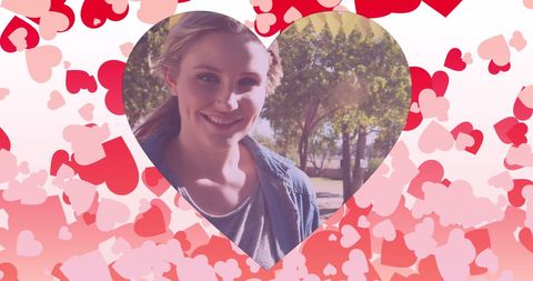 Smiling woman at park surrounded by heart designs