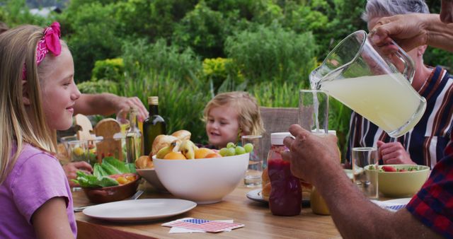 Smiling caucasian girl drinking lemonade at family celebration meal in garden - Download Free Stock Photos Pikwizard.com