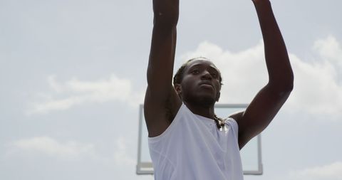 Athletic Man Shooting Basketball Outdoors Under Clear Sky