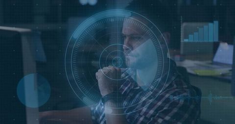 Contemplative Analyst Using HUD Data Visualization Overlaying Office Workstation Monitor