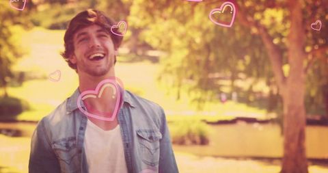 Smiling Man in Park with Romantic Pink Hearts Overlay