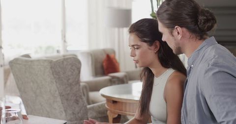 Couple collaborating on wedding plans using laptop at home