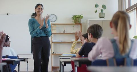 Dedicated Teacher Applauding Engaged Students in Bright Classroom