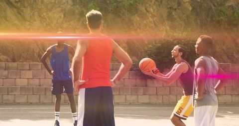 Outdoor street basketball friends playing and passing ball on sunlit neighborhood court