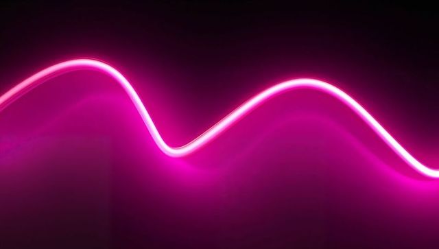 Glowing neon pink sine wave curves on dark background