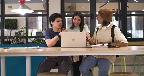 African American Students Collaborating Over Laptop Studying in Campus Commons