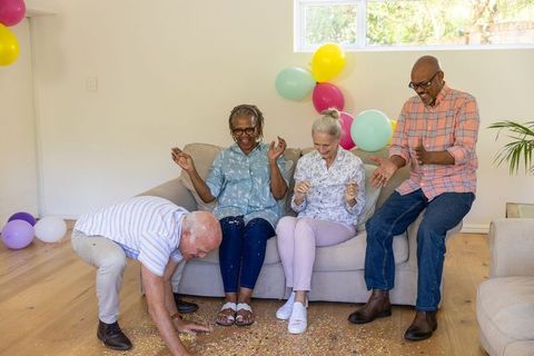 Diverse Group of Senior Friends Celebrating with Confetti and Balloons