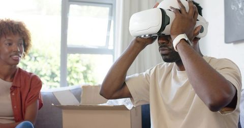 Young Couple Unboxing VR Headset at Home, Man Testing Virtual Reality Experience