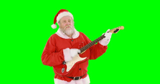 A Caucasian senior man dressed as Santa Claus is playing an electric guitar, with copy space on the green screen background. His cheerful expression and festive attire add a playful and holiday-themed vibe to the image.
