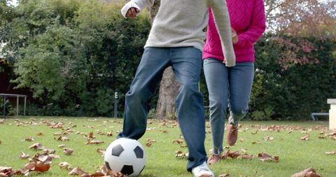 Mother and Little Child Playing Soccer in Autumn Garden