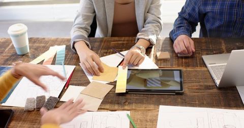 Creative team collaborating over fabric samples and design sketches