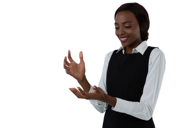 This image shows a happy woman gesturing with her hands while smiling. She is wearing business attire and standing against a white background. This image can be used for business presentations, communication training materials, or advertisements focusing on professional services and positive interactions.