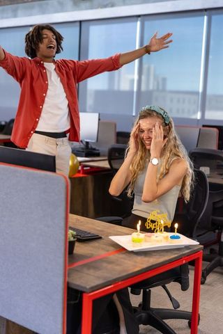 Team celebrating comfortable office birthday with surprise