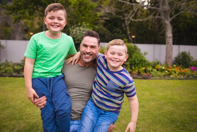 Happy Father with Two Sons Smiling in Garden - Download Free Stock Photos Pikwizard.com