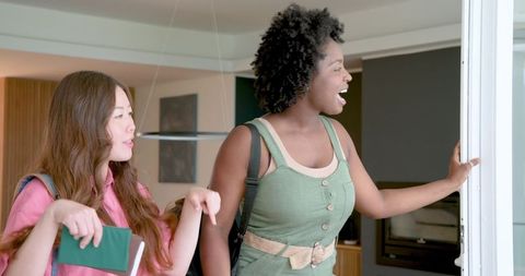 Excited Multiracial Female Friends Exploring Hotel Room on Vacation