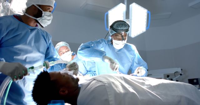 Diverse surgeons with face mask during surgery on african american male patient with oxygen mask. Medicine, healthcare, surgery and hospital, unaltered.