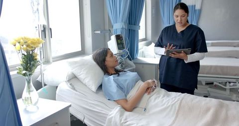 Patient in Hospital Bed Discussing Treatment with Doctor
