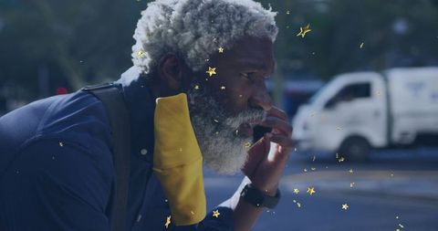 Gray-Bearded Man Leaning on City Roadside Touching Mouth with Yellow Mask and Gold Stars