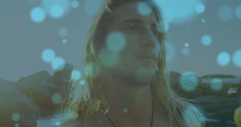 Thoughtful Young Man with Long Blonde Hair and Dreamy Bokeh Effect