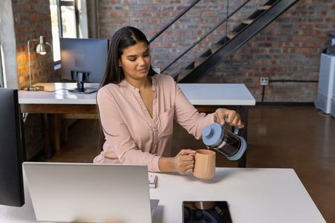 Professional Woman Brewing Coffee in Modern Office Environment
