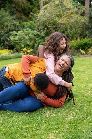 Diverse Family Enjoying Playful Moment in Backyard Garden
