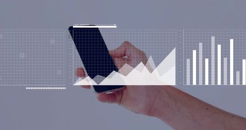 Holding smartphone showing data analytics with interactive graph overlays and bar charts