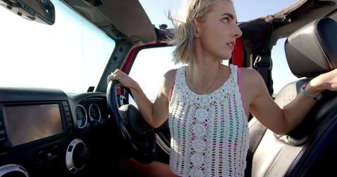 Young Blonde Woman Enjoys Road Trip in Convertible Car