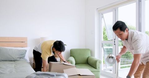 Father and Son Enjoying Packing Together in Bedroom