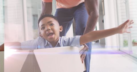 Happy African American Father and Son Playing with Cardboard Box