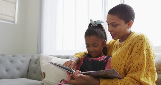 Mother Reading Book with Daughter on Cozy Sofa - Download Free Stock Images Pikwizard.com