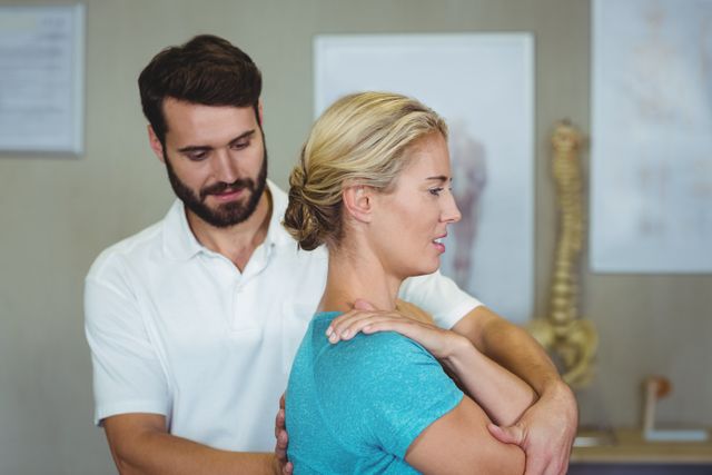 Male physiotherapist treating female patient in a clinic. Ideal for use in healthcare, wellness, and rehabilitation contexts. Can be used in articles, blogs, and promotional materials related to physical therapy, patient care, and medical treatments.