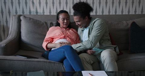 Happy Interracial Couple Bonding on Sofa, Relaxing At Home