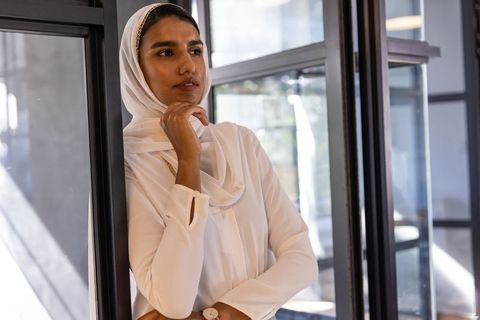 Confident Woman in Hijab Checking Time in Modern Office Environment