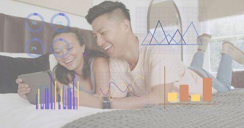 Adult couple lying on bed using tablet with augmented interactive data visualization overlays