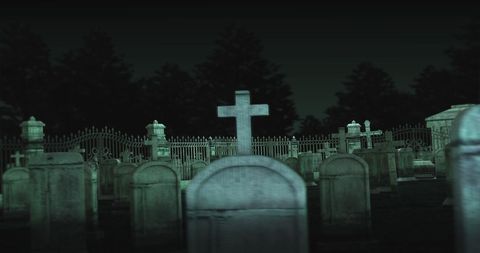 Eerie Nighttime Cemetery Scene with Tombstones and Crosses