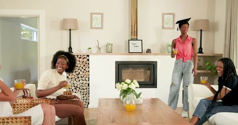 Joyful home graduation celebration with friends sharing laughter