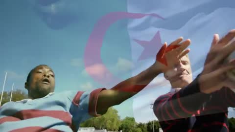 Rugby Players Competing on Sunny Pitch With Overlapping Flag