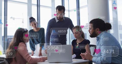Team lead guiding collaborative data review with social analytics overlays on laptop